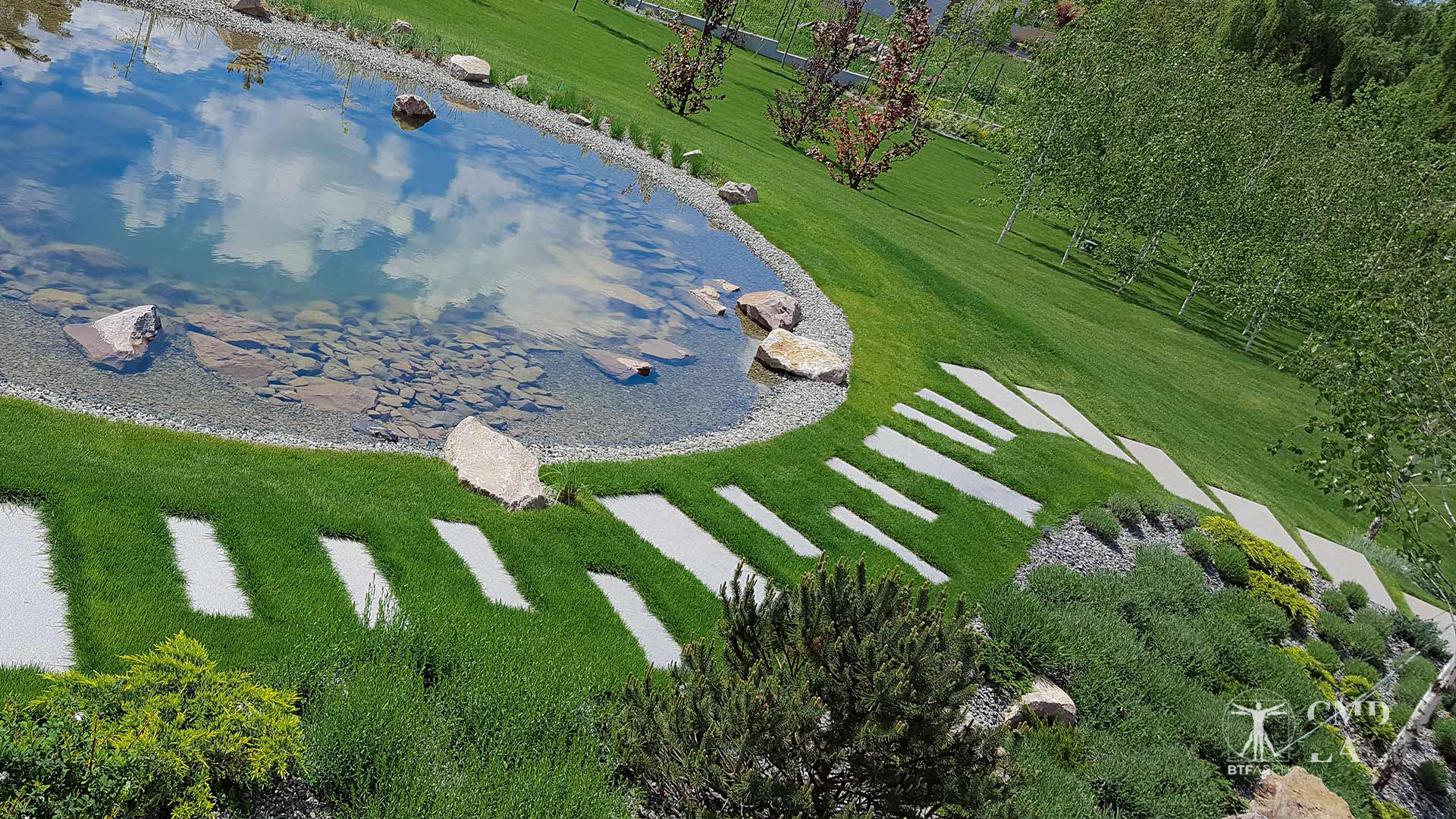 Alee din piatră naturală în jurul unui lac ornamental pe proprietate privată