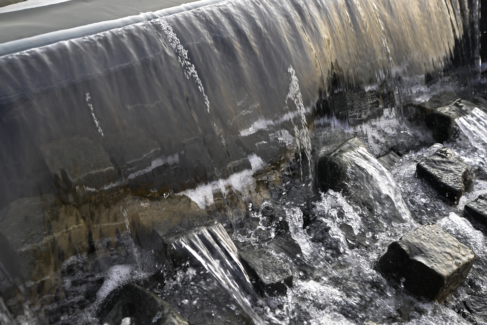 Detaliu cascadă cu apă curgătoare peste pietre naturale – amenajare peisagistică Ramatuelle