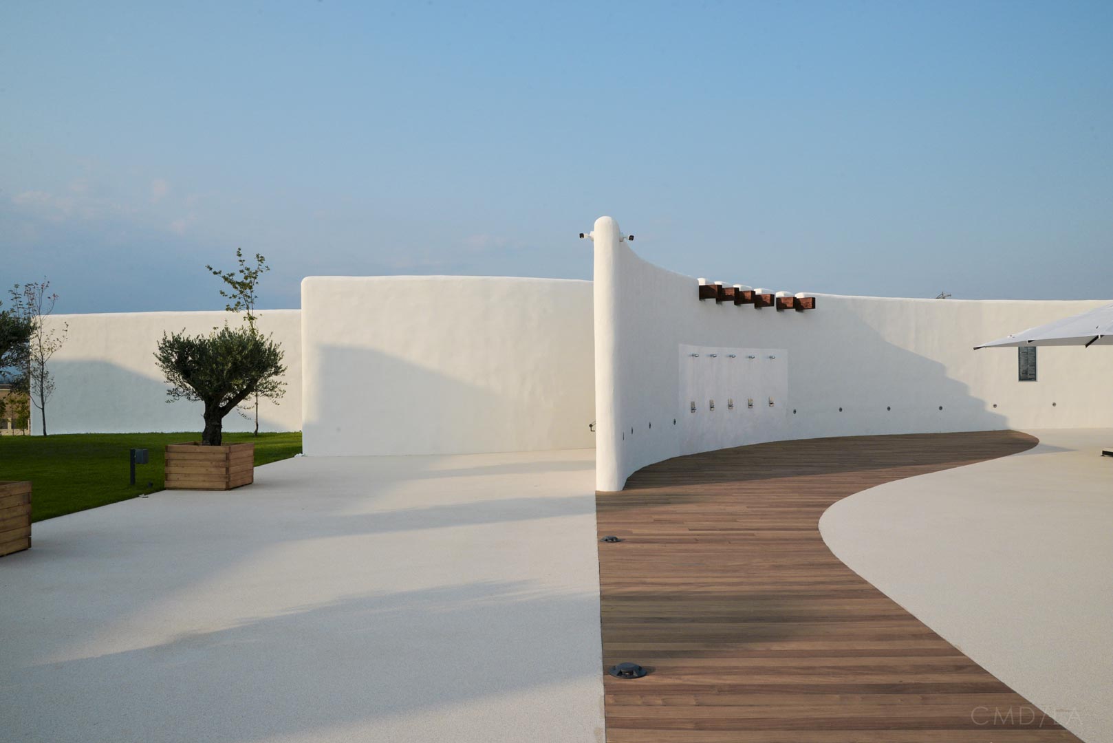 Spațiu de relaxare cu podea de lemn și pereți albi organici – elemente de design autentic mediteranean